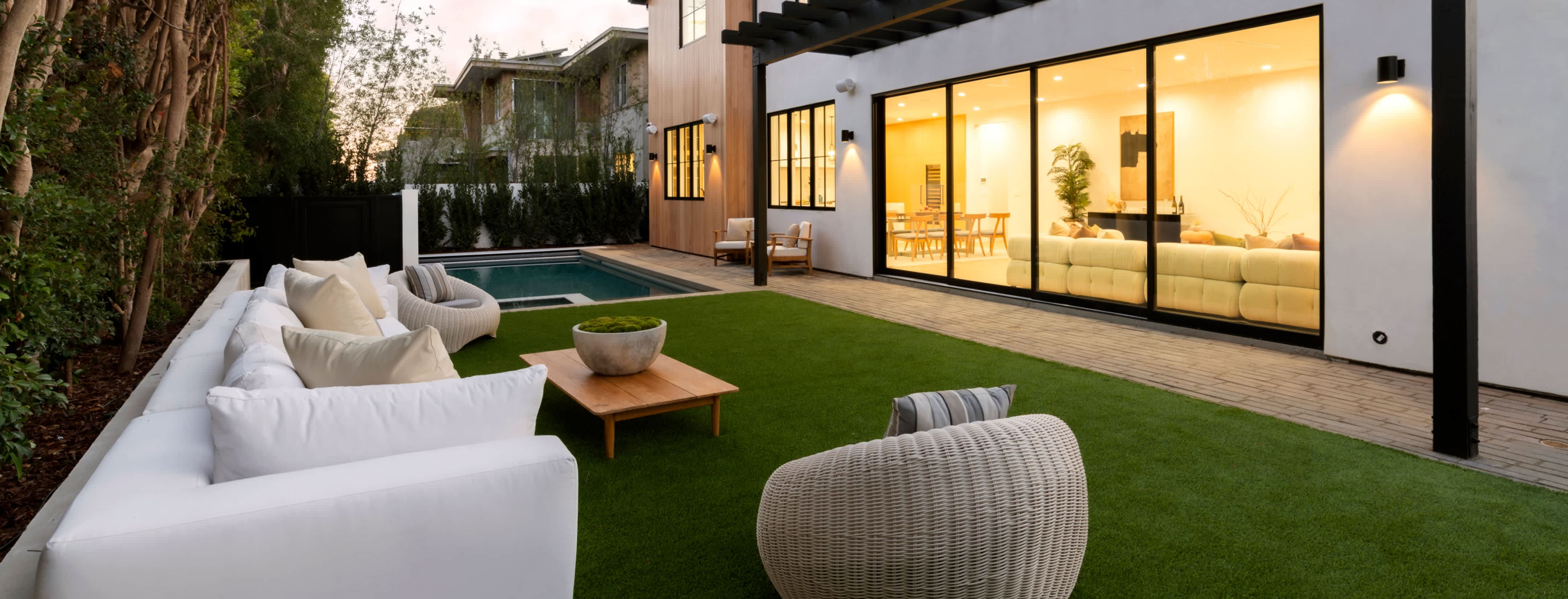 Clear huge sliding glass windows with in ground pool and outdoor furniture