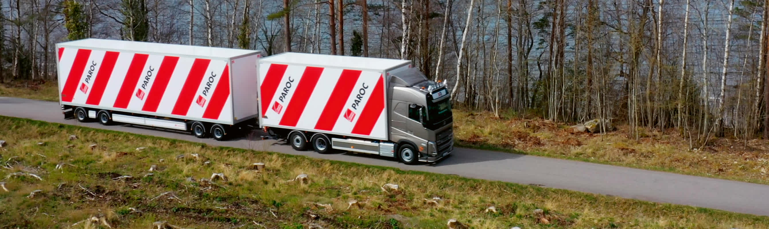 En röd-vit-randig lastbil på väg