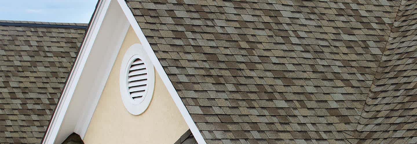 Closeup of a roof peak with Owens Corning Algae Resistant shingles.