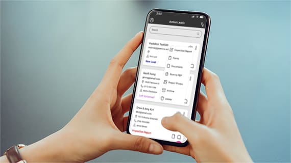 Hands holding a mobile phone with the Lead Management powered by Toolsey app displayed