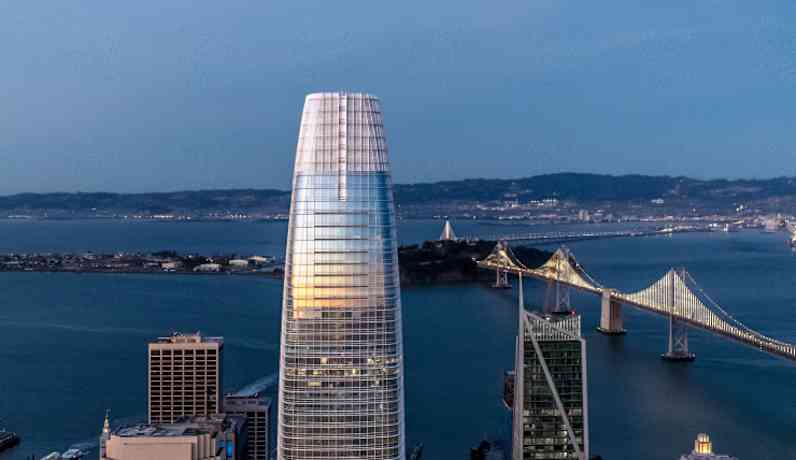 skyscraper overlooking water featuring bridge 