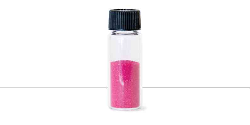 A vile of pink sand-like granules that are the color that is added to the PINK Next Gen™ Fiberglas™.